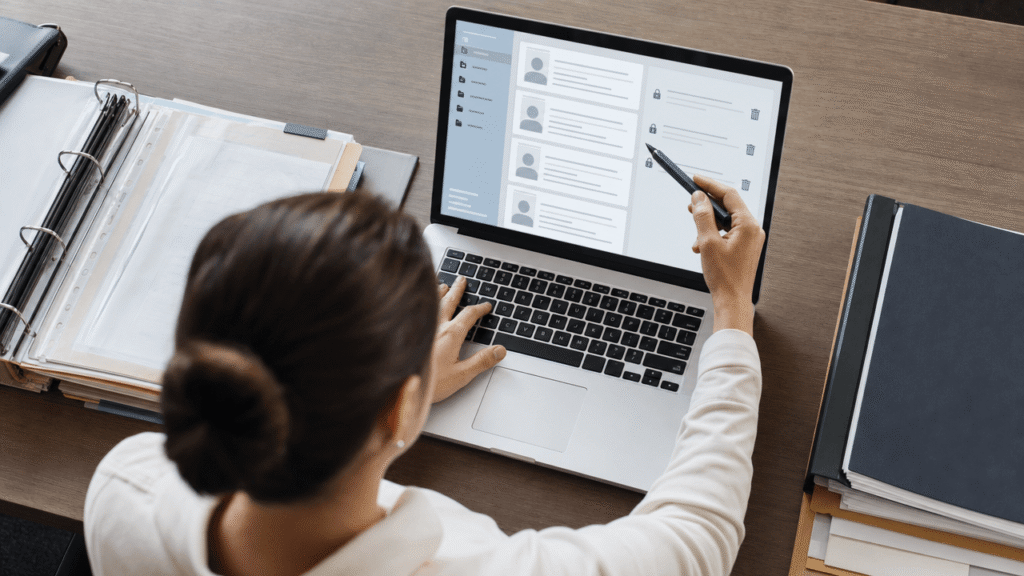 Person reviewing personal records on a laptop and paper documents